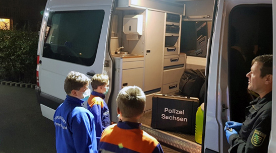 3 Kinder stehen vor Sprinter mit Polizist