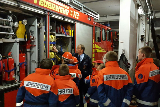 Jugendfeuerwehr steht vor offenem Löschfahrzeug