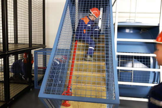 Kind sitzt auf einer Treppe, die mit Metall umzäunt ist