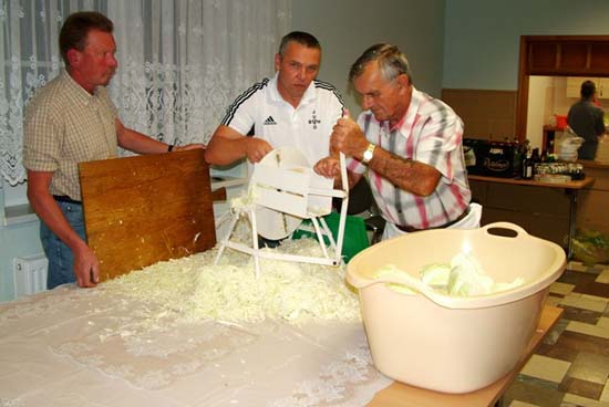 3 Männer schreddern das Weißkraut mit einer Maschine