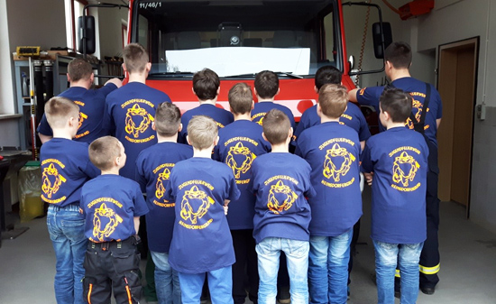 Jugendfeuerwehren zeigen ihr Logo auf dem T-Shirt auf dem Rücken