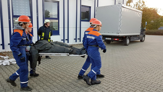 Jugendfeuerwehr trägt Puppe auf Brett