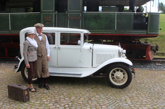Pärchen posiert neben weißem Oldtimer
