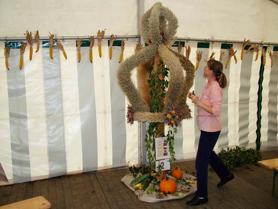 Frau begutachtet aufgestellte Erntekrone