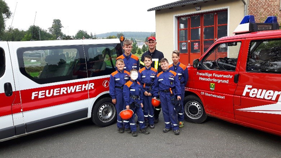 Jugendfeuerwehr posiert vor 2 Feuerwehrautos