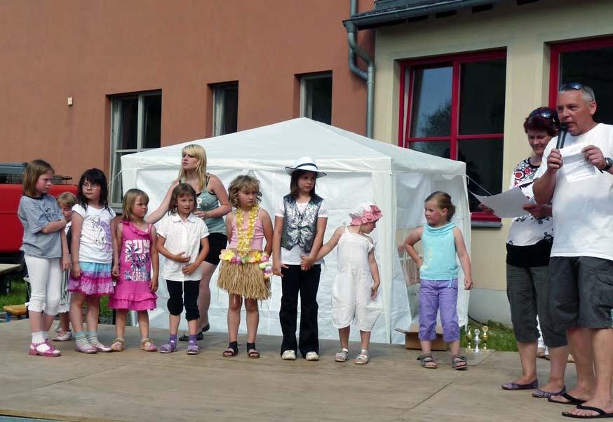 Kinder stehen in einer Reihe vor einem Zelt