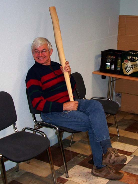 Mann hält stolz, mit Lächeln im Gesicht das Holz für des Sauerkraut in die Luft