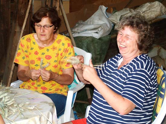 2 Frauen flechten das Korn