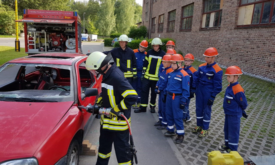 Feuerwehrkraft öffnet Autotüre mit Säge