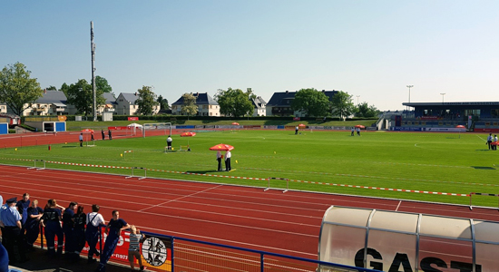Laufbahn in einem Stadion mit Gras in der Mitte