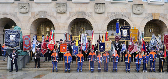 Fahnenkommandos mit Kammerad*innen stehen vor dem Rathaus in Dresden