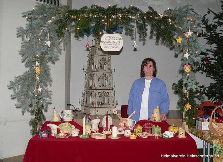 Frau steht hinter Tisch mit Weihnachtsdekoration