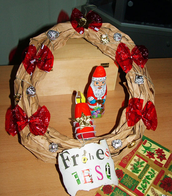 Weihnachtskranz aus Pappe und Plastik mit "Frohes Fest" Schild