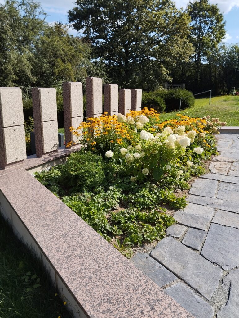 Ansicht verschiedener schön bepflanzter Gräber auf dem Friedhof