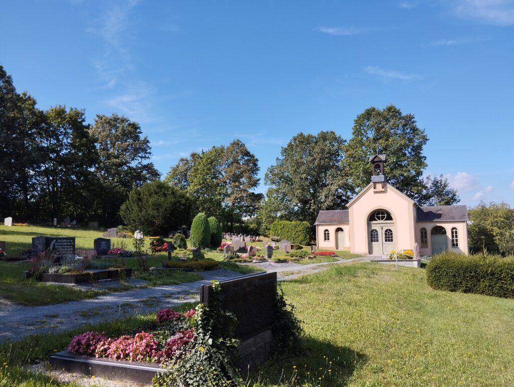 Blick auf den Friedhof mit Friedhofsgebäude im Hintergrund