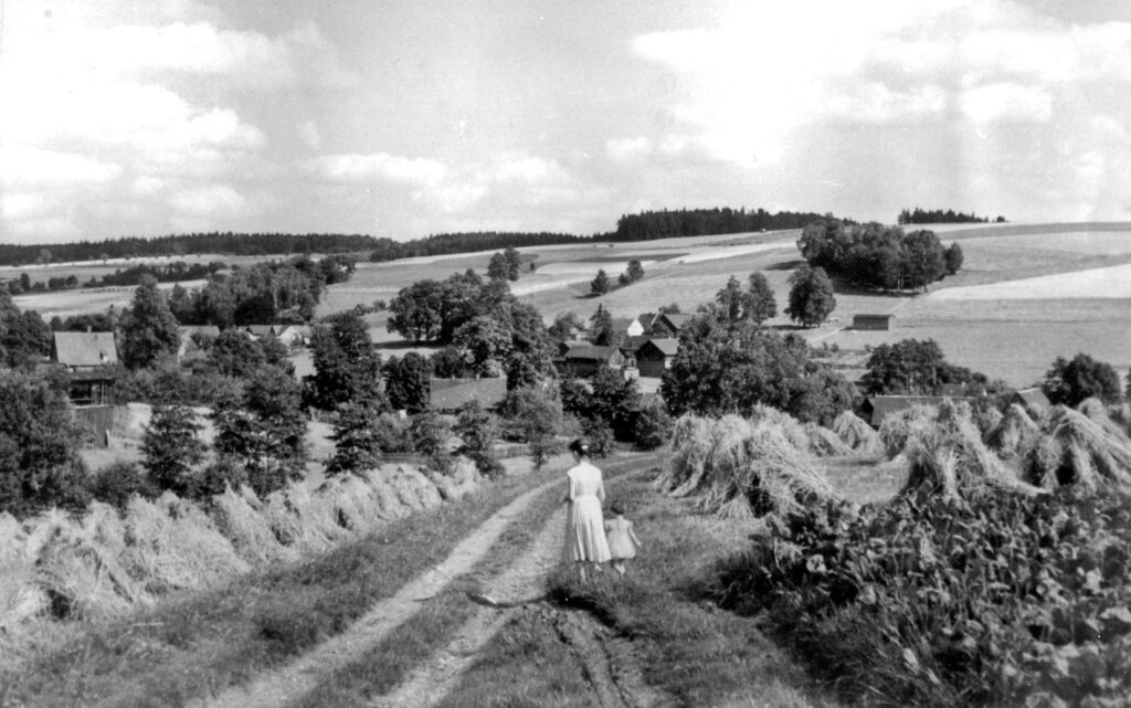 Schwarzweißbild Frau mit Kindläuft übers Feld