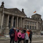 Zu sehen ist der Kindergemeinderat mit Bürgermeisterin Marion Dick und ihren Erziehungsberechtigten vor dem Bundestagsgebäude in Berlin.