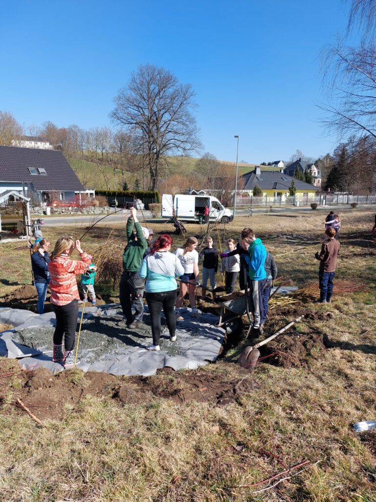 Das Bild zeigt die Helfer zum Arbeitseinsatz, wie sie das Weideniglu bauen.
