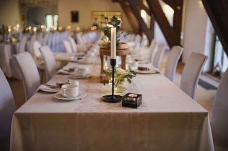 Nahansicht der Tischdeko für eine Hochzeit. Angezündete Kerzen und Tassen auf einer Tischdecke